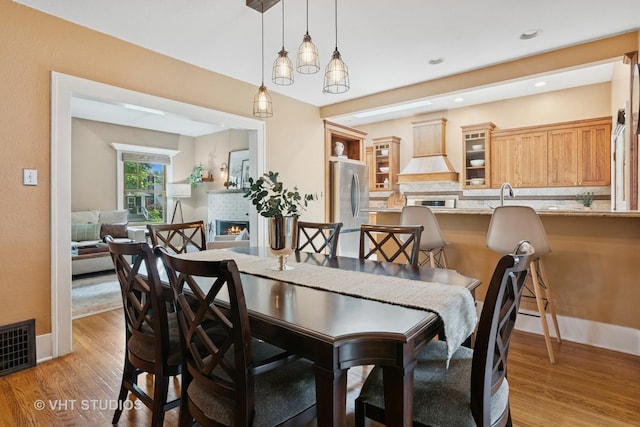 122 Logan Ave, Geneva, IL 60134 - dining room with light wood-style floors and a warm lit fireplace