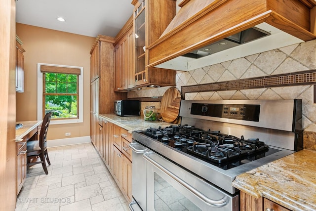 122 Logan Ave, Geneva, IL 60134 - kitchen featuring double oven range, premium range hood, brown cabinets, decorative backsplash, and recessed lighting
