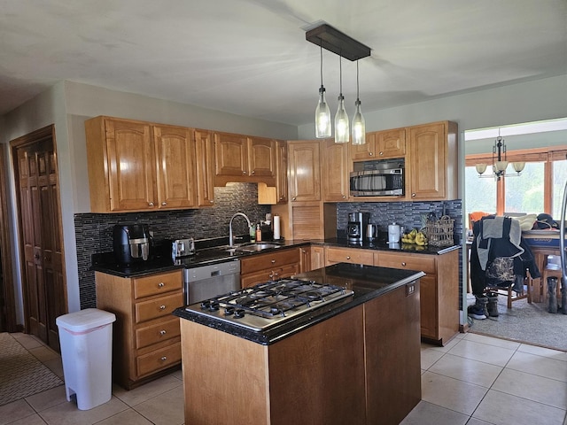 kitchen with appliances with stainless steel finishes, dark countertops, a sink, a notable chandelier, and light tile patterned flooring