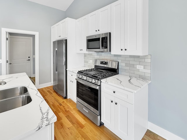 946 Partridge Cir, Marengo, IL 60152 - kitchen with light wood-style floors, white cabinets, tasteful backsplash, a sink, and stainless steel appliances
