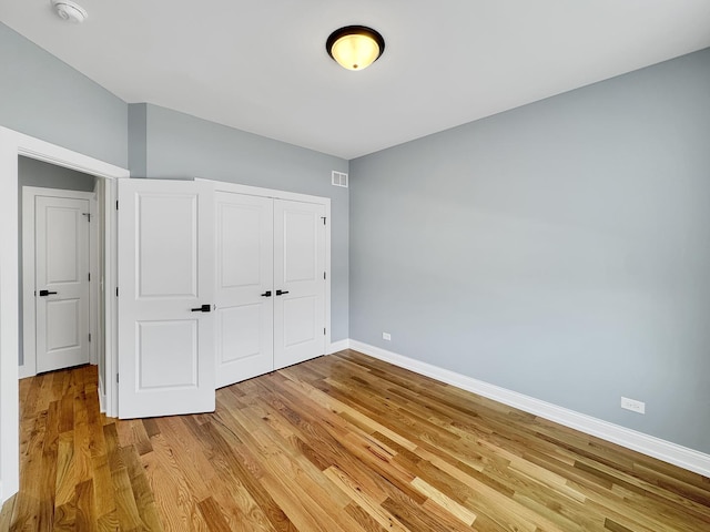 946 Partridge Cir, Marengo, IL 60152 - unfurnished bedroom with baseboards, visible vents, a closet, and light wood-type flooring
