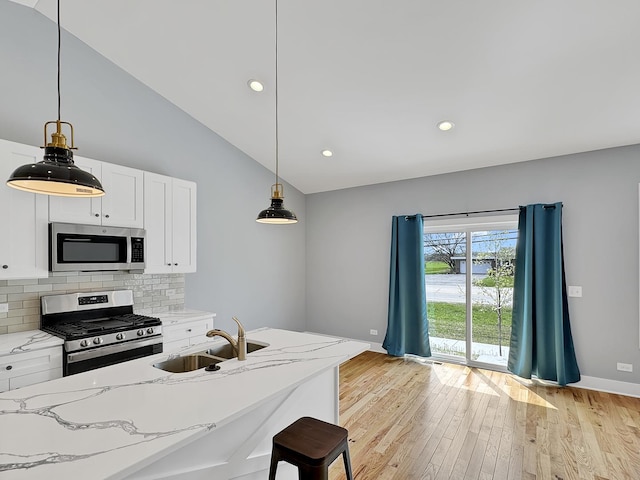 946 Partridge Cir, Marengo, IL 60152 - kitchen featuring light stone countertops, appliances with stainless steel finishes, a sink, light wood-style floors, and baseboards