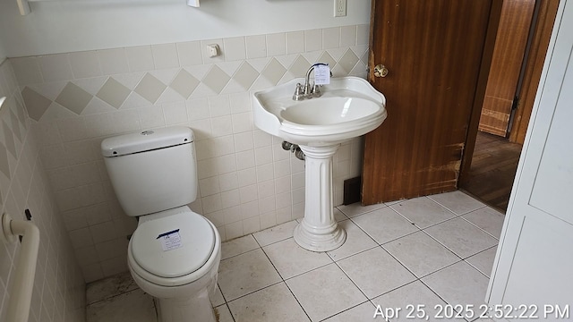 bathroom featuring toilet and tile walls