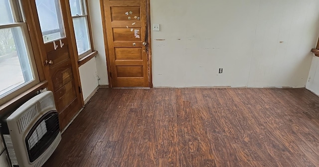 empty room with heating unit and dark wood finished floors