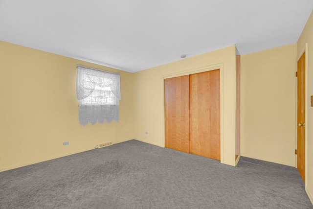 unfurnished bedroom with visible vents, carpet, and a closet