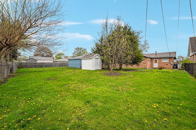 view of yard featuring an outdoor structure, a fenced backyard, and a storage shed