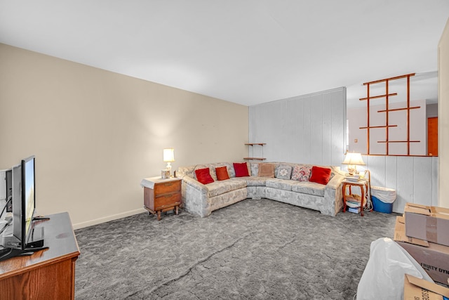 carpeted living area featuring wooden walls and baseboards