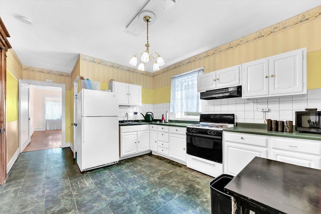 kitchen featuring freestanding refrigerator, black microwave, wallpapered walls, electric range oven, and under cabinet range hood