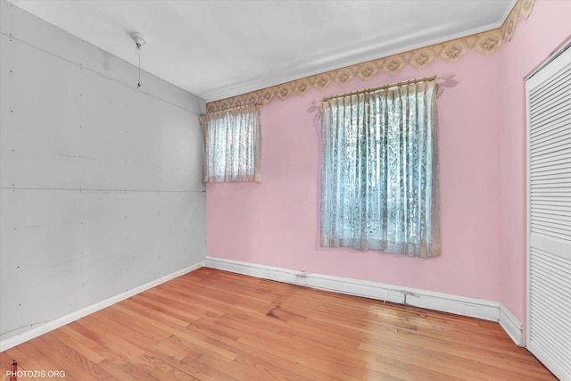 spare room featuring light wood-style floors and baseboards