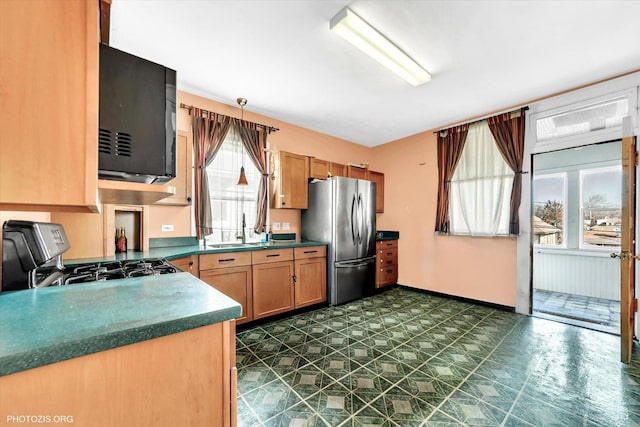 kitchen featuring black microwave, range with gas stovetop, freestanding refrigerator, and a wealth of natural light
