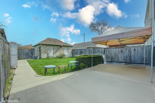 view of patio / terrace with concrete driveway, a fenced backyard, and a carport