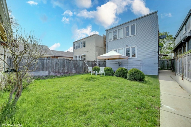 back of house with a lawn and a fenced backyard