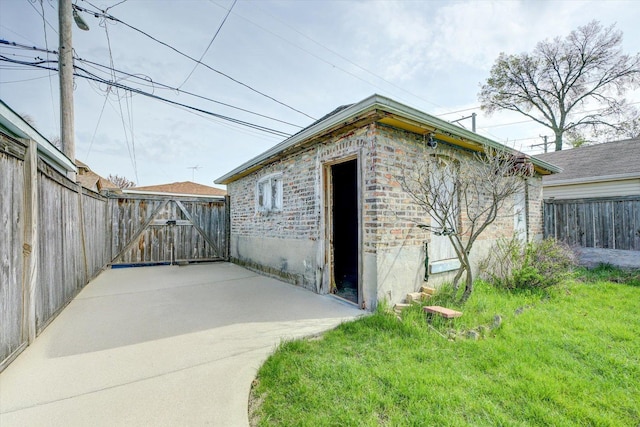 view of outbuilding featuring fence and a gate