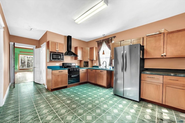 kitchen with a sink, dark countertops, stainless steel appliances, and wall chimney exhaust hood
