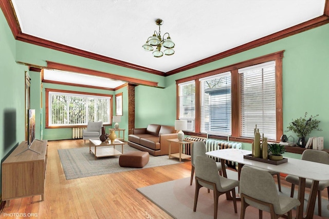 living room featuring crown molding, a notable chandelier, light wood finished floors, and cooling unit