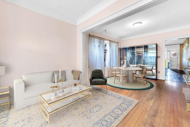 living area with baseboards, ornamental molding, and hardwood / wood-style floors