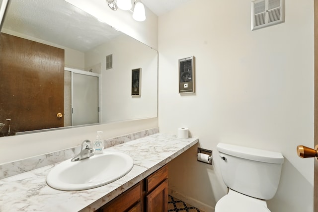 full bathroom featuring toilet, visible vents, a shower stall, and vanity