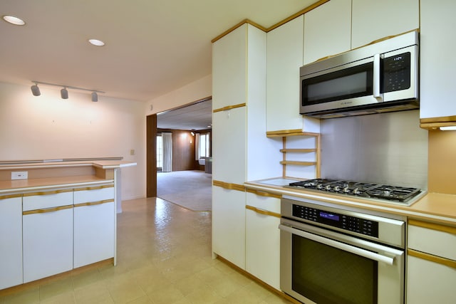 kitchen featuring track lighting, recessed lighting, light countertops, white cabinetry, and stainless steel appliances