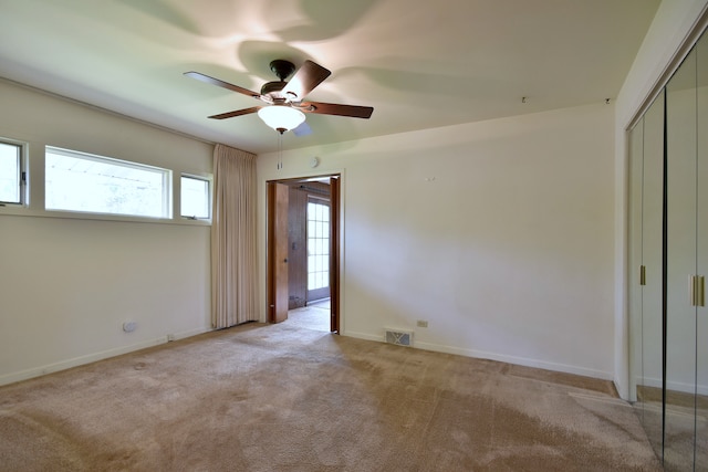 unfurnished bedroom featuring carpet flooring, a ceiling fan, baseboards, visible vents, and a closet