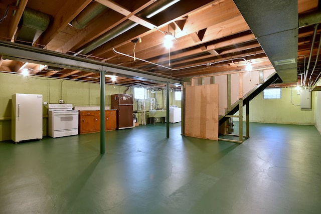 below grade area with a sink, freestanding refrigerator, washer / clothes dryer, and electric panel