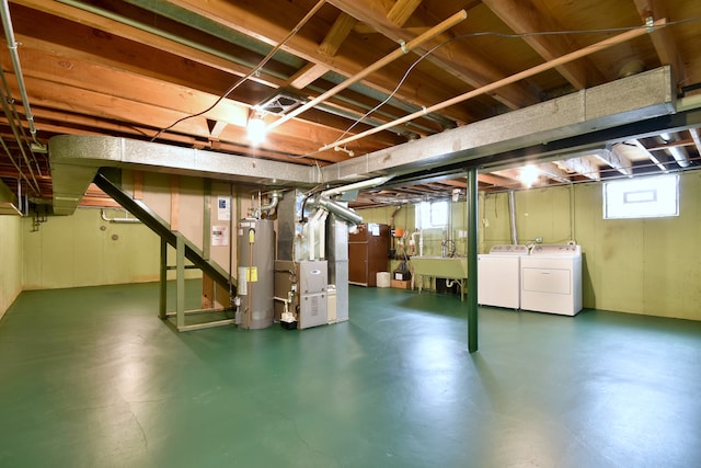 basement featuring heating unit, washing machine and dryer, stairway, a sink, and water heater