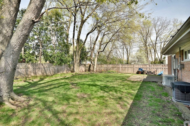 view of yard with a fenced backyard and central AC