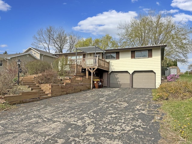 view of front of property with a wooden deck, a garage, stairway, aphalt driveway, and a pergola