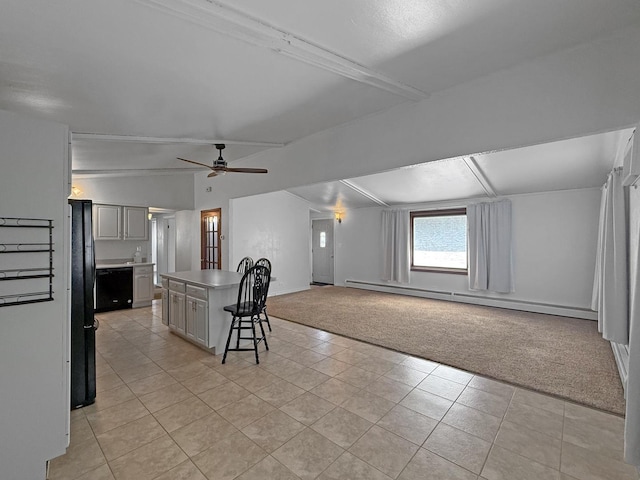 interior space featuring light colored carpet, baseboard heating, a center island, a ceiling fan, and open floor plan