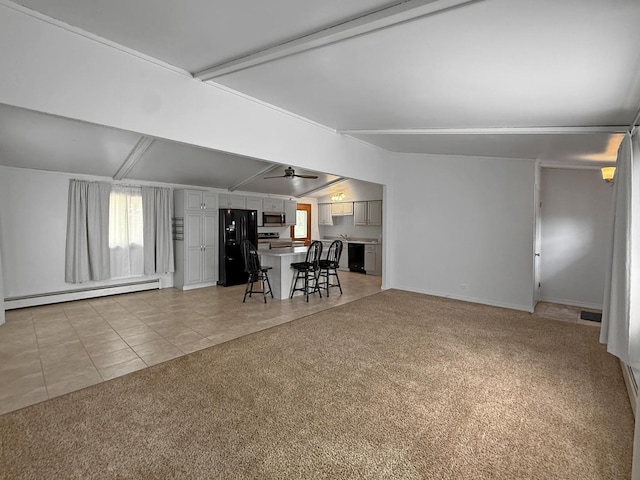 living area with plenty of natural light, a baseboard radiator, light tile patterned floors, and light carpet
