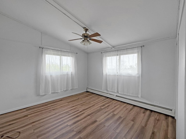 spare room featuring wood finished floors, a baseboard radiator, lofted ceiling, and a wealth of natural light