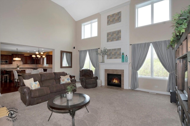 16650 W Merc Ln, Lockport, IL 60441 - living room with a tiled fireplace, a notable chandelier, high vaulted ceiling, and light colored carpet