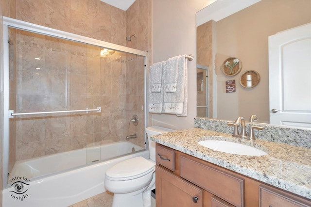 full bath with vanity, bath / shower combo with glass door, and toilet