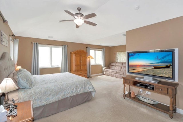 carpeted bedroom with ceiling fan, vaulted ceiling, baseboards, and visible vents