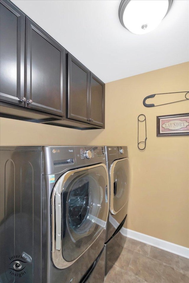 washroom featuring baseboards, cabinet space, and washing machine and clothes dryer