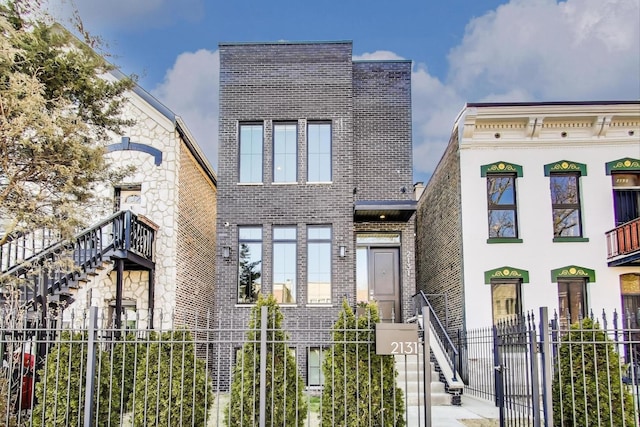view of front facade with brick siding and fence