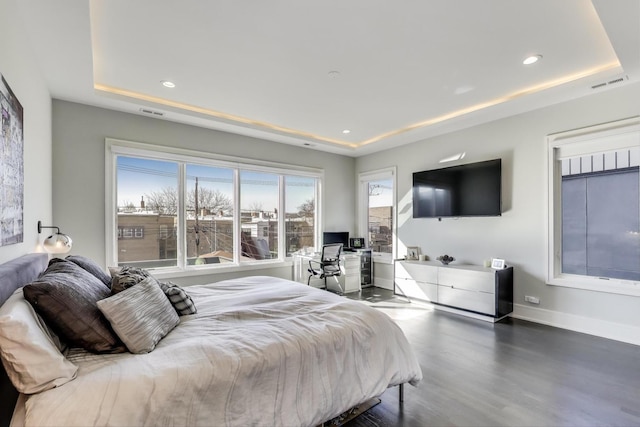 bedroom featuring visible vents, wood finished floors, a raised ceiling, baseboards, and recessed lighting