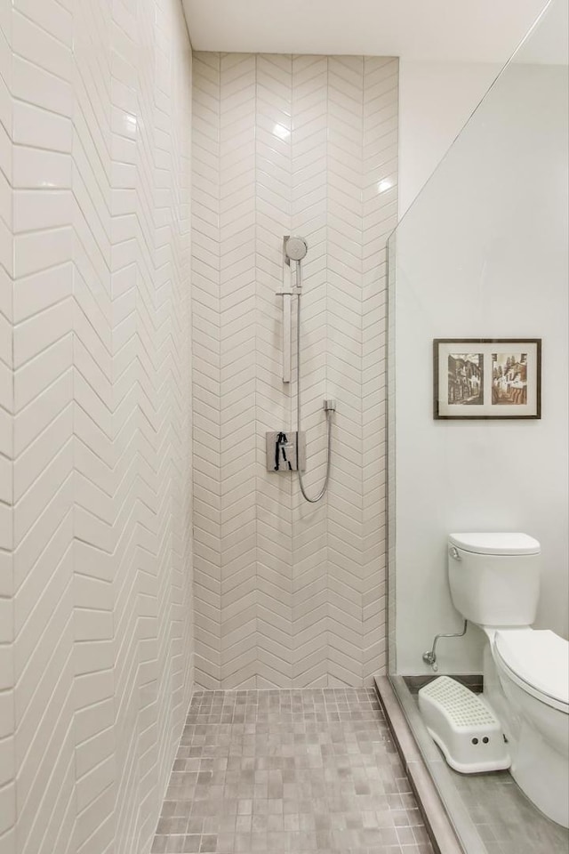 full bath featuring a tile shower and toilet
