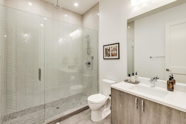 full bath featuring toilet, a shower stall, and vanity