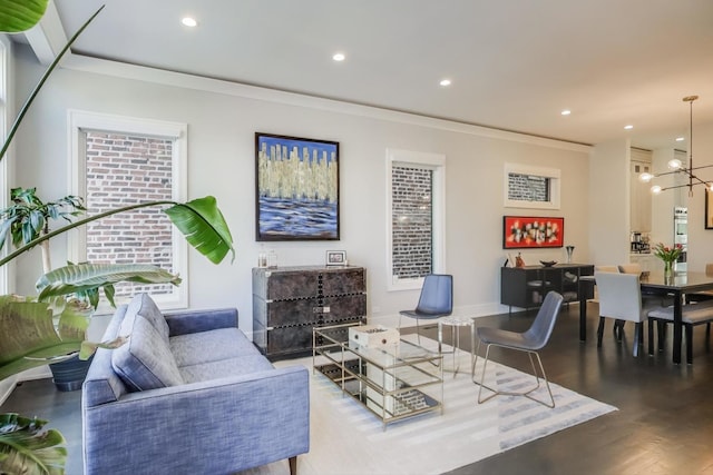 living area featuring crown molding, recessed lighting, wood finished floors, and a chandelier