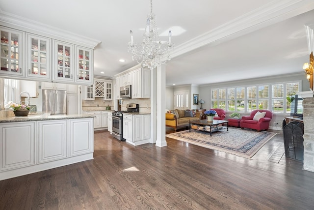 214 E Woodland Rd E, Lake Bluff, IL 60044 - living area with crown molding, an inviting chandelier, a stone fireplace, recessed lighting, and dark wood-type flooring