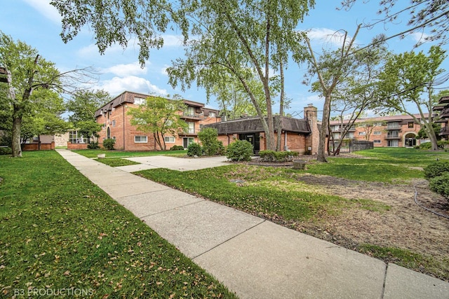 2345 185th Ct Unit 25, Lansing, IL 60438 - view of front facade featuring brick siding, a chimney, and a front lawn