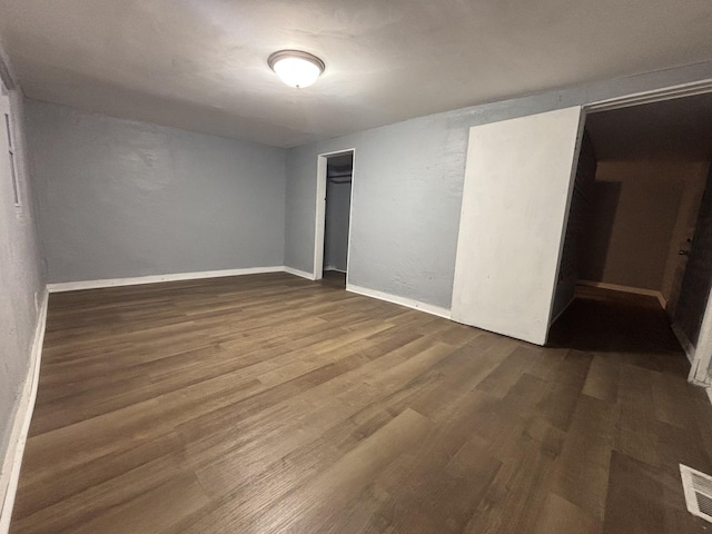 unfurnished bedroom with wood finished floors, baseboards, visible vents, and a closet