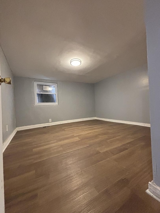empty room featuring dark wood finished floors and baseboards