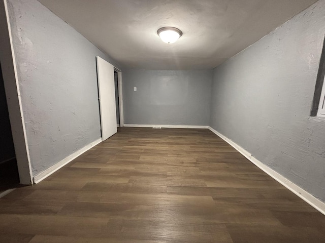 empty room featuring wood finished floors and baseboards