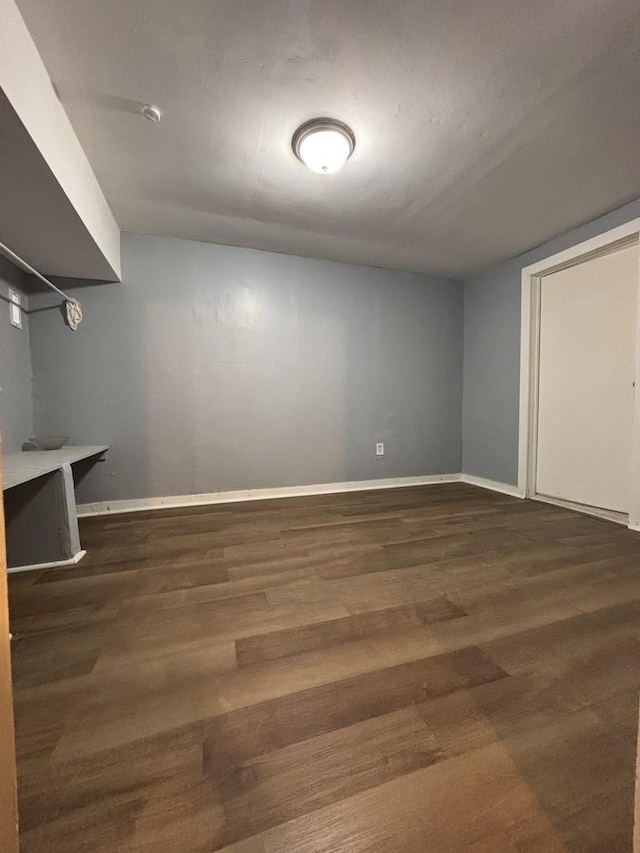 finished below grade area featuring dark wood-style floors and baseboards