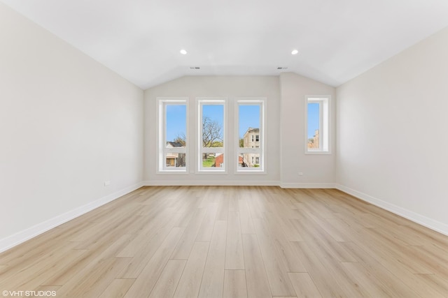 interior space with light wood-style floors, baseboards, and lofted ceiling
