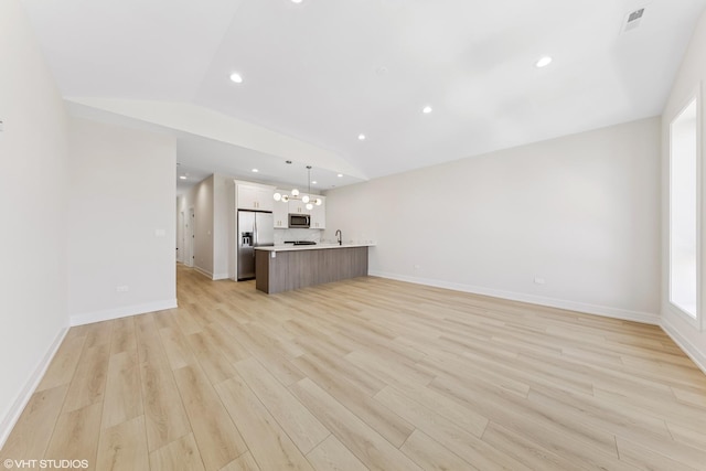 unfurnished living room with a notable chandelier, light wood-style flooring, recessed lighting, lofted ceiling, and visible vents
