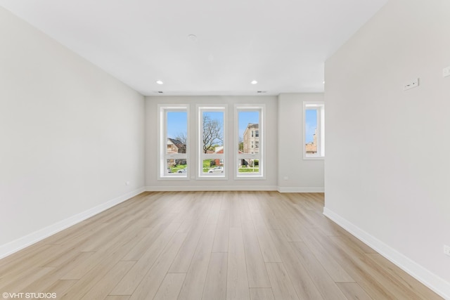 unfurnished living room with baseboards, plenty of natural light, and light wood-type flooring