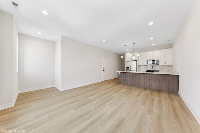 kitchen featuring recessed lighting, light wood-style flooring, appliances with stainless steel finishes, and white cabinetry