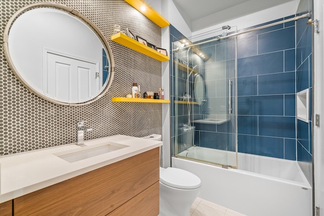 bathroom featuring vanity, tile patterned flooring, toilet, bath / shower combo with glass door, and backsplash